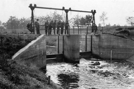 848473 Gezicht op de stuw Pothbrug te Woudenberg in het Valleikanaal, met op de stuw een groep medewerkers van ...